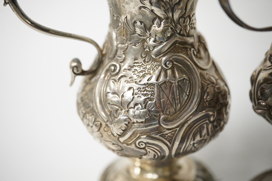 Two Georgian silver cream jugs, with later embossed decoration, inverted pyriform, London, 1782, the other London, 1773 (a.f.). Condition - poor to fair